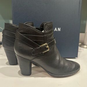 Cole Haan black leather booties with side xip, novelty trim and gold buckle.